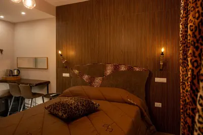 a bedroom with a bed and a table and a desk at Jacuzzi Rooms Vatican Museum in Rome