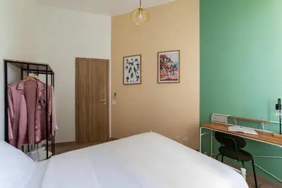 a bedroom with a bed and a desk and a dressing room at Kaizen The Barista 3BR Apartment With Coffee Station in Rome