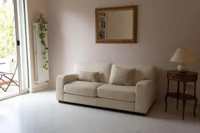 a white couch in a living room with a mirror at Tiziano apartment-a spacious home for you in Rome in Rome