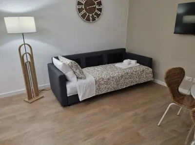 a bedroom with a bed and a chair and a clock at Al Fontanile in Rome