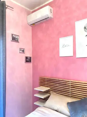 a bedroom with a pink wall with a bed at La Casa di G Metro A tra Vaticano e Gemelli in Rome