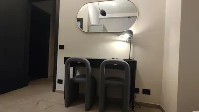 a bathroom with two chairs and a mirror at Auri Vatican apartment in Rome