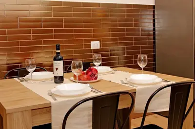 a table with a bottle of wine and a bowl of fruit at TM Apartment in Rome
