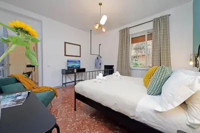 a bedroom with a bed and a couch and a television at TM Apartment in Rome
