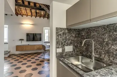 a kitchen with a sink and a living room at Cisterna 9 in Rome