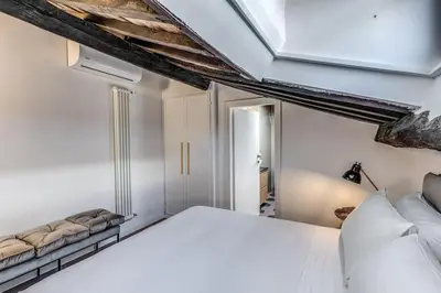 a bedroom with a white bed and a ceiling at Cisterna 9 in Rome