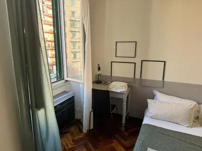 a room with a desk and a bed and a window at A Colorful Spot for La Dolce Vita in Rome