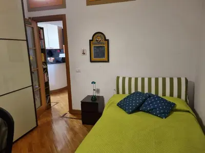 a bedroom with a green bed with two pillows on it at Casa BiBi in Rome