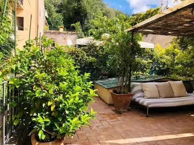 a patio with a couch and some potted plants at Stylish Duplex Apartment with Private Terrace in Rome