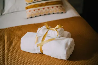 a pile of towels with a ribbon on a bed at Interno Otto con Bellissima Terrazza e Gazebo in Rome