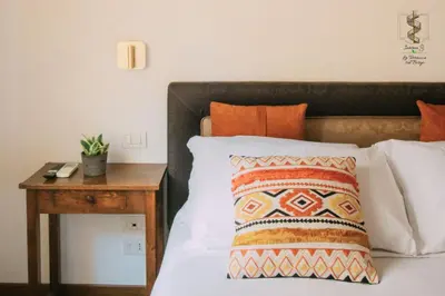 a bed with a night stand next to a bed with a pillow at Interno Otto con Bellissima Terrazza e Gazebo in Rome