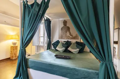 a bedroom with a bed with green curtains at Navona Dream Flat in Rome