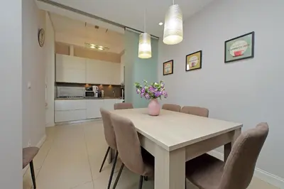 a dining room table with chairs and a vase of flowers on it at 4BNB - Armot House Vatican Apartment in Rome