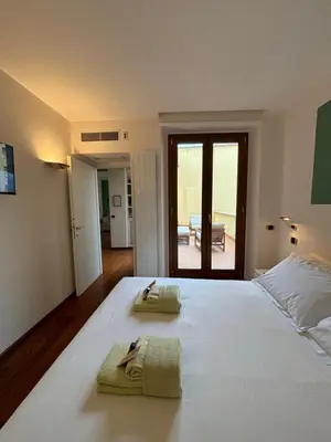 a bedroom with a large white bed with towels on it at Vincent's Place, Vatican City in Rome