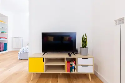 a living room with a tv on a tv stand at L'Appartamentino a San Giovanni in Rome