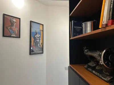 a room with two pictures on the wall and a shelf at ROMA Metro A in Rome