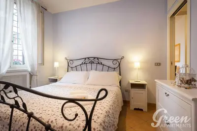 a bedroom with a bed with a white bedspread at Green Apartments Rome in Rome