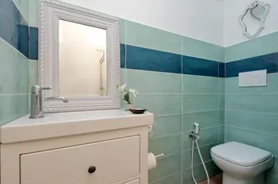 a bathroom with a toilet and a sink and a mirror at Trastevere 50DUE Apartment in Rome