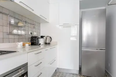 a kitchen with white cabinets and a stainless steel refrigerator at Vatican Stay in Rome