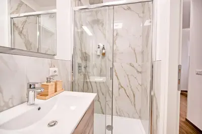 a white bathroom with a shower and a sink at Caesar's quarters - private rooms in Rome in Rome