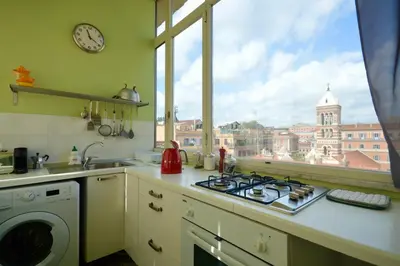 a kitchen with a stove top oven next to a window at Splendido attico a Roma in Rome