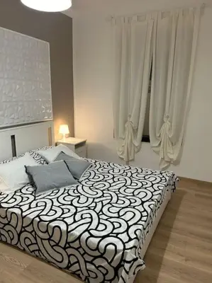 a bedroom with a bed with a black and white blanket at Caroline Home in Rome