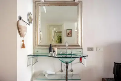 a bathroom with a glass sink and a mirror at Angi's home the new Luxury in Rome heart in Rome
