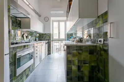a large kitchen with green tiles on the wall at Angi's home the new Luxury in Rome heart in Rome