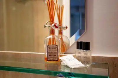 a bottle of soap sitting on a counter in front of a mirror at Angi's home the new Luxury in Rome heart in Rome