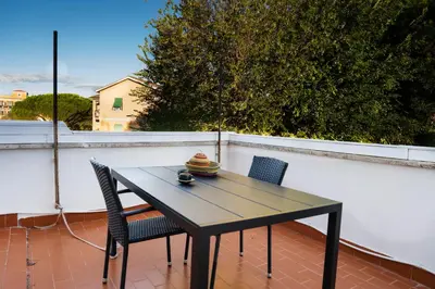 a wooden table and two chairs on a balcony at Rooftop Apartment Quadraro in Rome