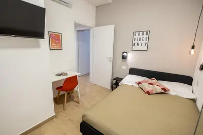 a small bedroom with a bed and a desk at Re di Roma Ela Apartment in Rome