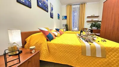 a bedroom with a yellow bed with a yellow comforter at Casa Simpatia Roma Vaticano in Rome