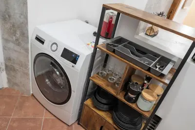 a washing machine sitting in a kitchen next to a shelf at Home Domus Capocci - Rione Monti in Rome