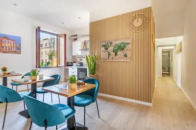 a kitchen and dining room with tables and blue chairs at La casa di Elba in Rome