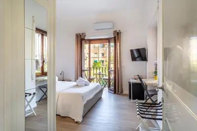 a bedroom with a bed and a desk and a window at La casa di Elba in Rome