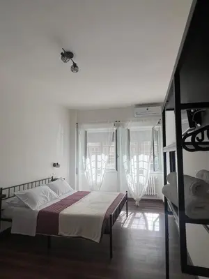 a bedroom with a bed and two windows at Sweet RHome in Rome