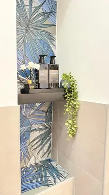 a shelf in a bathroom with two products on it at Casa Gaia - Cozy Urban Oasis in Rome