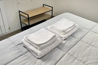 a bed with white towels on it with a table at La maisonette romana in Rome