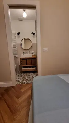 a bedroom with a bed and a bathroom with a mirror at Maggie's House in Rome