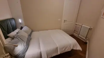 a small bedroom with a white bed in it at Maggie's House in Rome