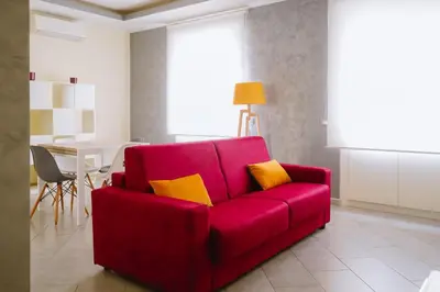 a red couch with yellow pillows in a living room at Domus Gianicolensis in Rome