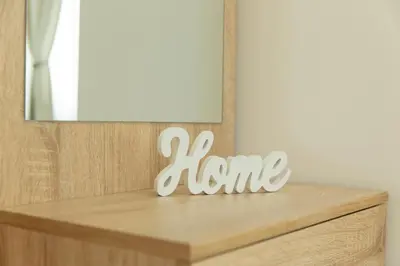 a wooden home sign on a dresser in front of a mirror at Casa Sole in Rome