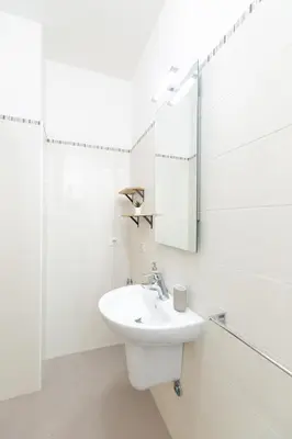 a white bathroom with a sink and a mirror at Casa Sole in Rome