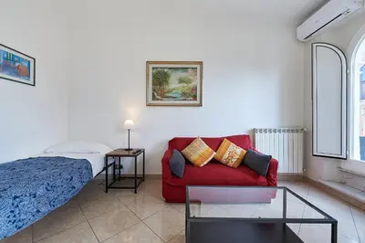 a bedroom with a bed and a red couch at Close to the Spanish Steps, WIFI, Air Cond, 2 bedrooms in Rome