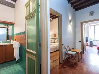a bathroom with a green door and a bedroom at Piazza Navona Charming Apartment in Rome