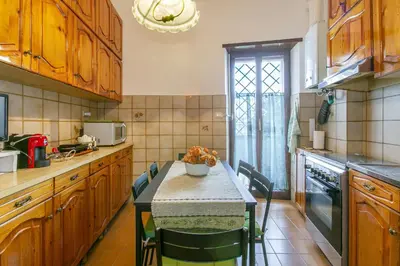 a kitchen with a table and chairs in it at Rosso Levanto House in Rome