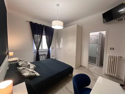 a bedroom with a black bed and a blue chair at A casa di Pina - Roma St Peter in Rome