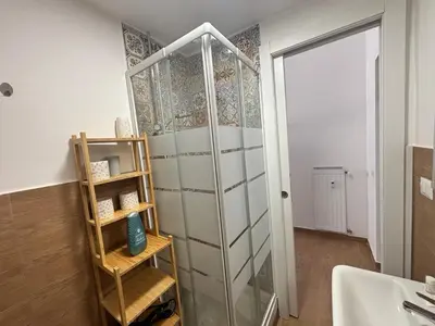 a glass shower door in a bathroom next to a sink at Vaticano Apartment in Rome