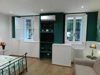 a living room with a bed and two windows at Sweet Rome Holiday Flaminio-The biggest shower in Rome