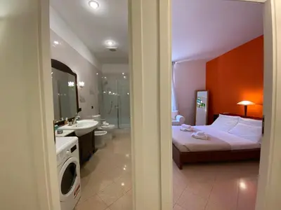 a bedroom with a bed and a bathroom with a sink at Idi's House in Rome